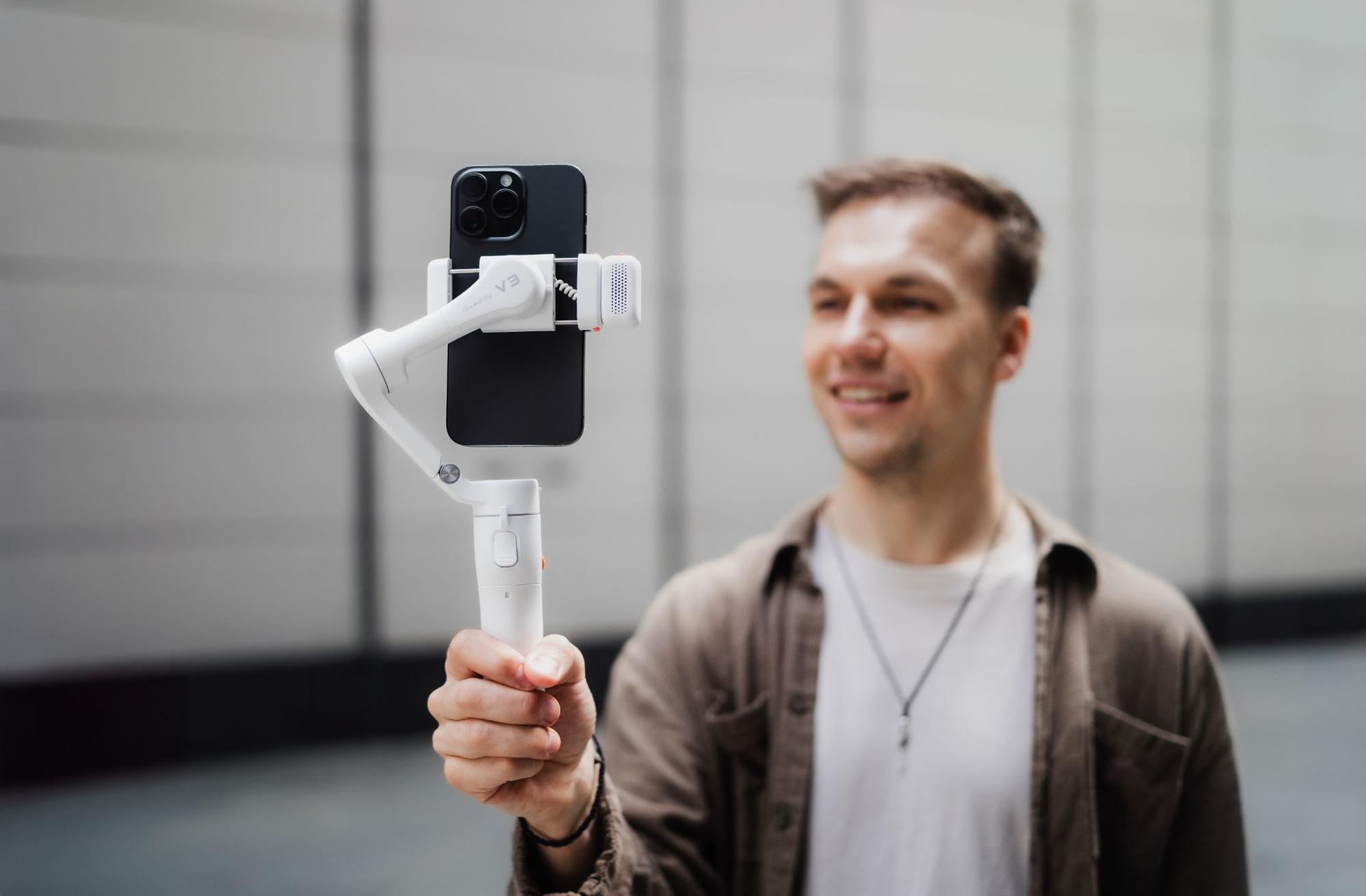 The Hohem iSteady V3 being held by a man who is vlogging.